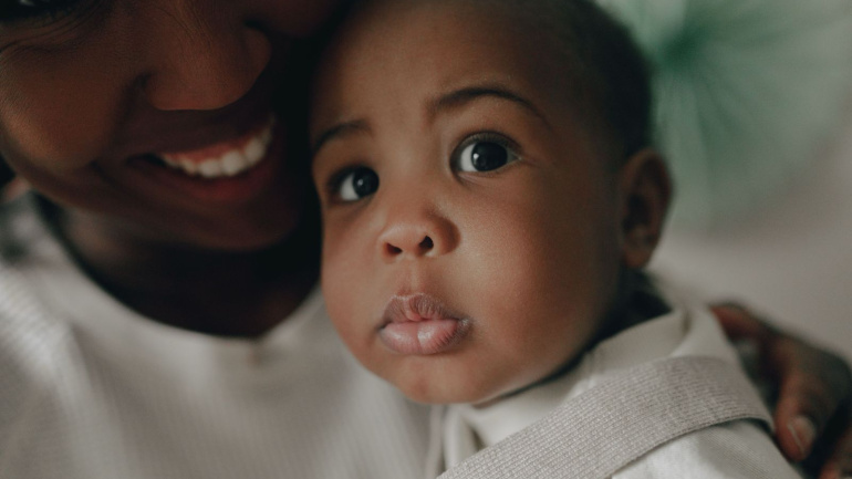 Madre sonriente abraza con ternura a su bebe